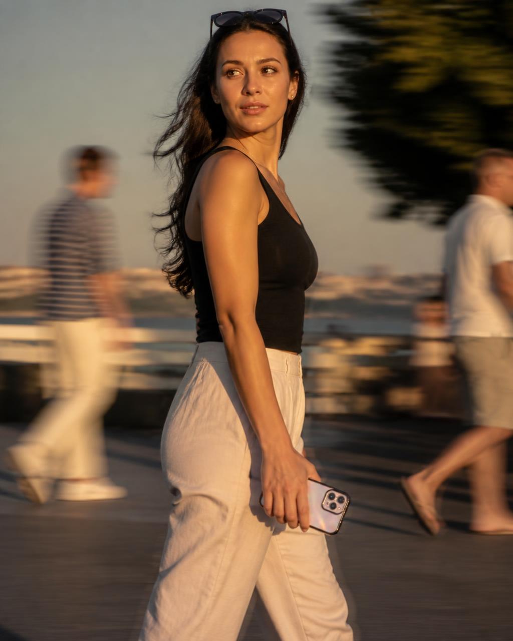 Woman walking with an iPhone in an iridescent case